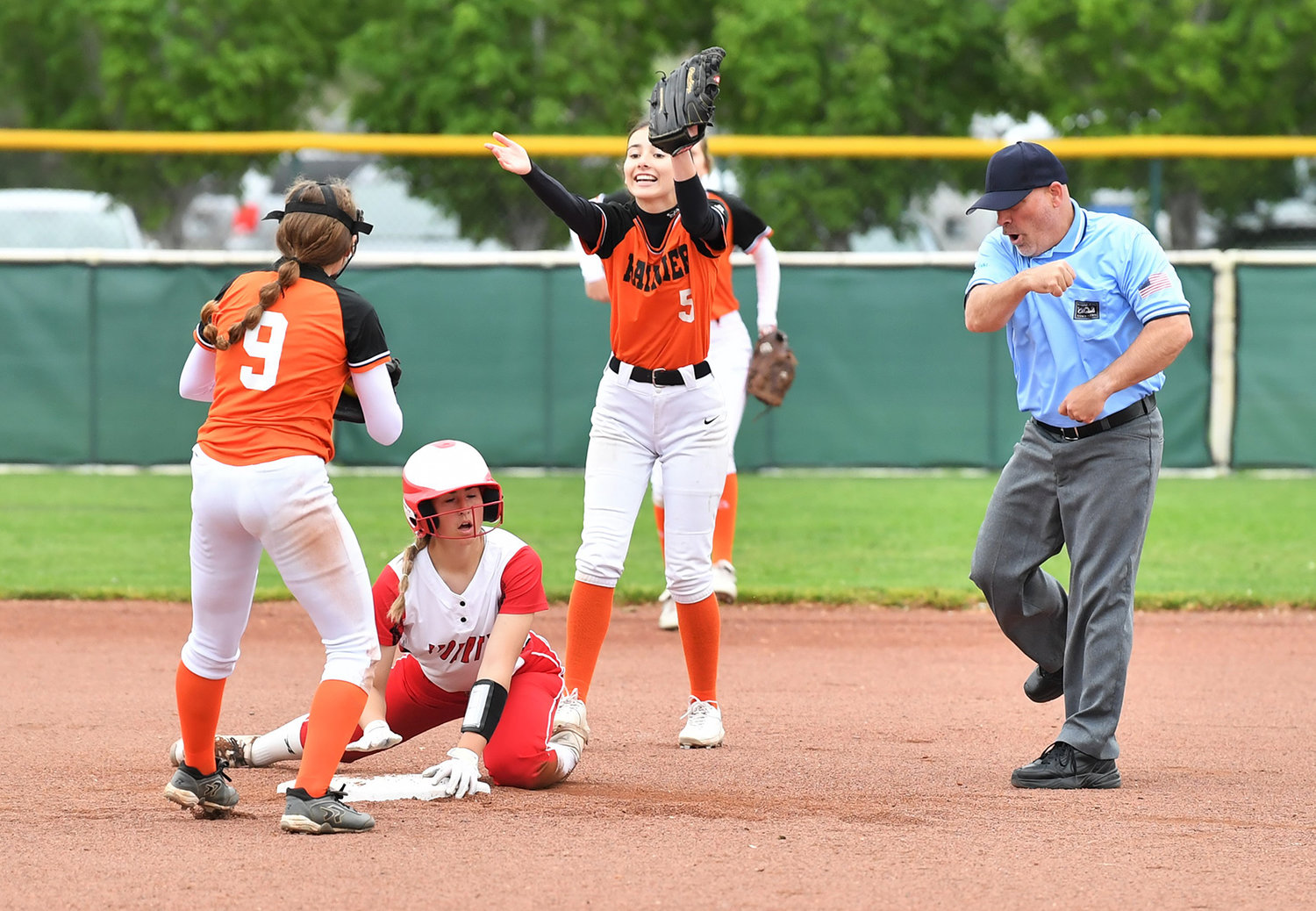 Rainier's Brooklynn Swenson (9) and Alyssa Lofgren (5) react as a Liberty player is called out on an attempted stolen base during the first round of the 2B state softball tournament in Yakima Friday morning.